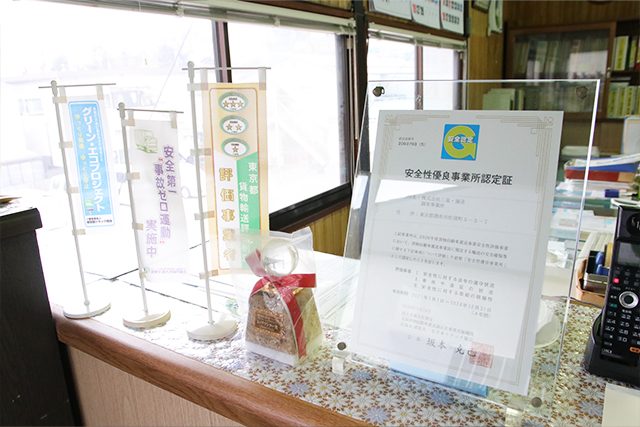 安全性優良事業所認定書とトップランナー賞トロフィーの写真